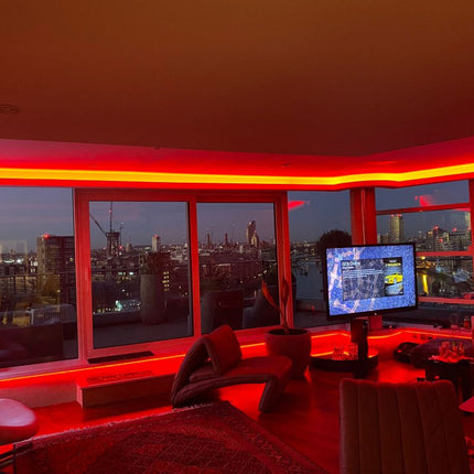 Red illuminated curved cove within London cityscape view apartment