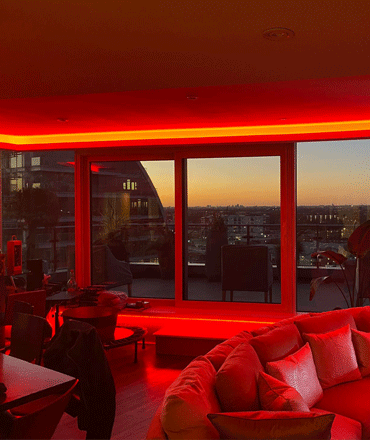 Deep red amber cove and pelmet LED lighting effect. London cityscape.